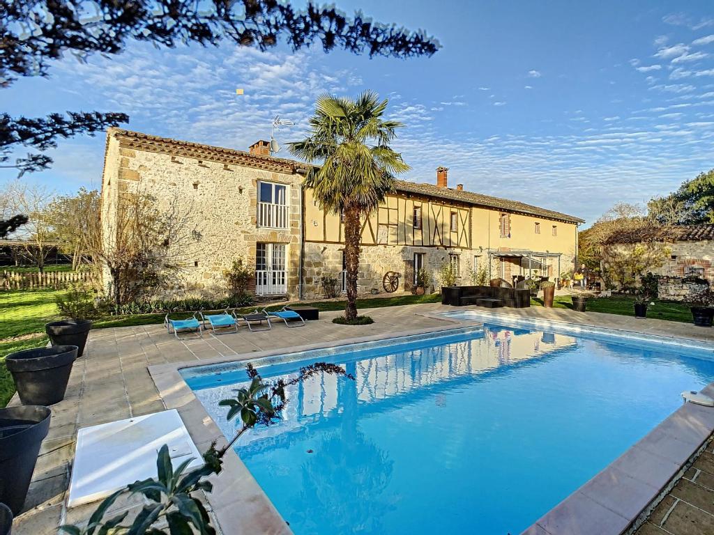 Piscine et maison en pierre des Gîtes Sainte-Catherine à Teyssode